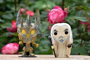Kara Lord Sauron ve Yüzüklerin Efendisi 'ndeki Beyaz Büyücü Saruman' ın aksiyon figürleri. Gizemli karamsar bahçe, kırmızı güller.
