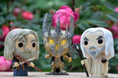 Gri Gandalf, Sauron ve Yüzüklerin Efendisi 'ndeki Beyaz Saruman' ın aksiyon figürleri. Gizemli karamsar bahçe, kırmızı güller.