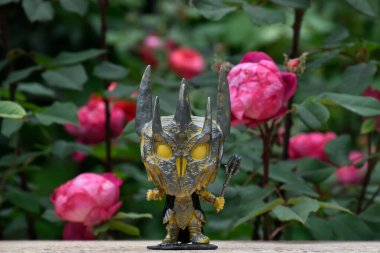 Yüzüklerin Efendisi filmindeki Karanlık Lord Sauron 'un aksiyon figürü Funko Pop. Gizemli karamsar bahçe, kırmızı güller, kasvetli yer.