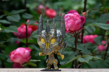 Yüzüklerin Efendisi filmindeki Karanlık Lord Sauron 'un aksiyon figürü Funko Pop. Gizemli karamsar bahçe, kırmızı güller, kasvetli yer.