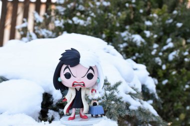 101 Dalmaçyalı animasyon filmindeki kötü karakter Cruella de Vil 'in Funko Pop aksiyon figürü. Kış, köknar ağacının dallarında bembeyaz kar.