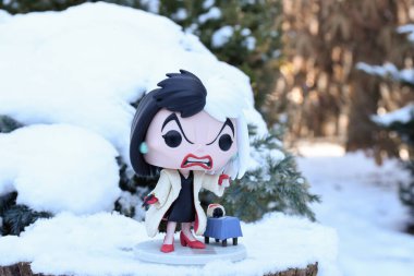 101 Dalmaçyalı animasyon filmindeki kötü karakter Cruella de Vil 'in Funko Pop aksiyon figürü. Kış, köknar ağacının dallarında bembeyaz kar.
