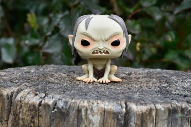 Gollum 'un fantezi filmi Yüzüklerin Efendisi' ndeki Funko Pop figürü. Karanlık orman, ağaç kütüğü, yeşil yapraklar..