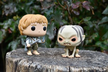 Fantezi filmi Yüzüklerin Efendisi 'ndeki Hobbit Sam ve Gollum' un aksiyon figürleri. Karanlık orman, ağaç kütüğü, yeşil yapraklar..
