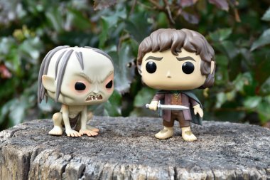 Gollum 'un aksiyon figürleri ve Yüzüklerin Efendisi' ndeki hobbit Frodo. Karanlık orman, ağaç kütüğü, yeşil yapraklar..