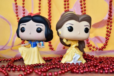 Disney prenseslerinin aksiyon figürleri Pamuk Prenses ve Belle (Güzel ve Çirkin). Pembe perde, kırmızı kolye, muhteşem saray.