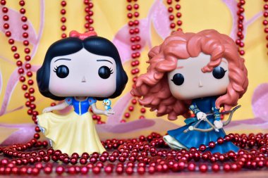 Disney prenseslerinin aksiyon figürleri Pamuk Prenses ve Merida (Cesur). Pembe perde, kırmızı kolye, muhteşem saray.