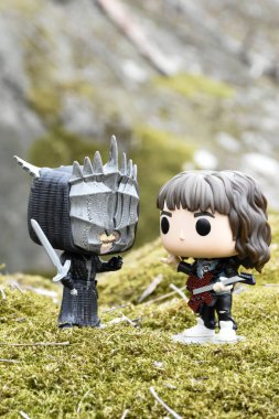 Sauron 'un Ağzı (Yüzüklerin Efendisi) ve Yabancı Şeyler' den Eddie Munson 'ın aksiyon figürleri. Yosunlu kayalar, vahşi doğa, vadi, atmosferik yer. 