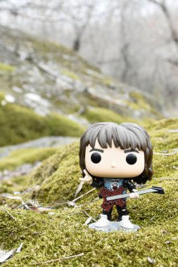 Korku dizisi Stranger Things 'ten Eddie Munson' ın funko pop aksiyon figürü. Yeşil yosunlu kayalar, vahşi orman, vadi, atmosferik yer. 