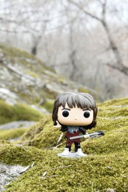 Korku dizisi Stranger Things 'ten Eddie Munson' ın funko pop aksiyon figürü. Yeşil yosunlu kayalar, vahşi orman, vadi, atmosferik yer. 