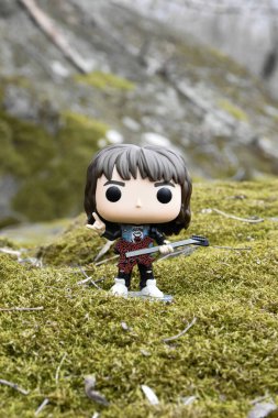 Korku dizisi Stranger Things 'ten Eddie Munson' ın funko pop aksiyon figürü. Yeşil yosunlu kayalar, vahşi orman, vadi, atmosferik yer. 