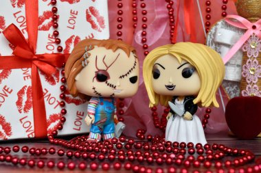 Korku filmlerindeki Chucky ve Tiffany 'nin aksiyon figürleri. Sevgililer Günü, el yapımı melek, hediye kutusu, kolye, kırmızı kurdele, kalp.
