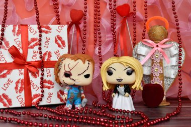 Funko Pop action figures of Chucky and Tiffany from horror movies Child's Play. Valentine's Day, handmade angel, gift box, necklace, red ribbons, hearts.