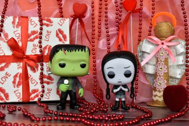 Frankenstein 'ın canavarı ve çarşamba Addams' ın aksiyon figürleri. Sevgililer günü, el yapımı melek, hediye kutusu, kolye, kırmızı kurdele, kalpler, romantizm.