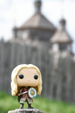 Eowyn 'in Funko Pop aksiyon figürü, Rohan' ın asil kadını, Yüzüklerin Efendisi adlı fantezi filmindeki bakire. Eski ahşap kale kuleleri, yüksek kapılar.