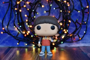 Popüler Netflix TV dizisi Stranger Things 'ten Will Byers' ın Funko Pop aksiyon figürü. Mavi sisli arka plan, renkli ışıklar, perili, gizemli bir yer..