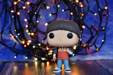Popüler Netflix TV dizisi Stranger Things 'ten Will Byers' ın Funko Pop aksiyon figürü. Mavi sisli arka plan, renkli ışıklar, perili, gizemli bir yer..