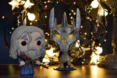 Büyücü Gri Gandalf ve Yüzüklerin Efendisi 'ndeki Karanlık Lord Sauron' un aksiyon figürleri. Sıcak aydınlatma, siyah arkaplan, karanlık yer.