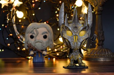 Büyücü Gri Gandalf ve Yüzüklerin Efendisi 'ndeki Karanlık Lord Sauron' un aksiyon figürleri. Sıcak aydınlatma, siyah arkaplan, karanlık yer.
