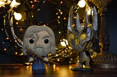 Büyücü Gri Gandalf ve Yüzüklerin Efendisi 'ndeki Karanlık Lord Sauron' un aksiyon figürleri. Sıcak aydınlatma, siyah arkaplan, karanlık yer.