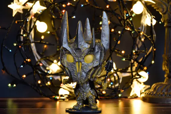 Yüzüklerin Efendisi filmindeki Karanlık Lord Sauron 'un aksiyon figürü Funko Pop. Renkli çelenk ışıkları, sıcak ışıklandırma, siyah arka plan, kasvetli bir yer.. 