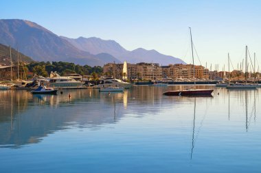 Güneşli kış gününde güzel Akdeniz manzarası. Karadağ, Adriyatik Denizi. Tivat şehri ve Kotor Körfezi manzarası. Dağlar, şehir ve yelkenliler sakin sulara yansıyor