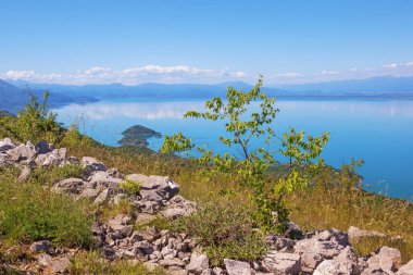 Dağlarla çevrili güzel mavi göl, Karadağ 'daki Skadar Gölü Ulusal Parkı manzarası 