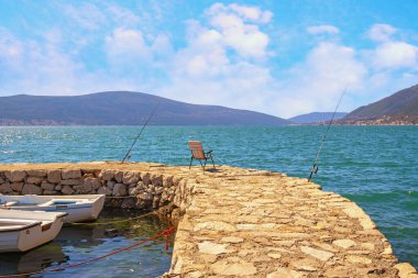 Kıyıda balık tutmak. Güneşli bir günde güzel Akdeniz manzarası. Karadağ, Tivat kenti Donja Lastva köyü yakınlarındaki Kotor Körfezi manzarası