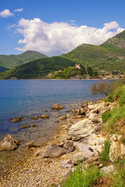 Güzel Akdeniz manzarası. Karadağ. Kotor Körfezi kıyısında, Verige Boğazı yakınlarında. Kamenari köyü ve Kutsal Pazar Kilisesi uzakta. 