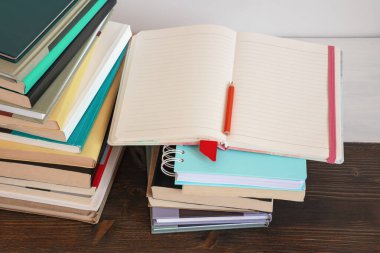 Bir yığın kitap ve kırsal masada açık bir defter. Boşluğu kopyala