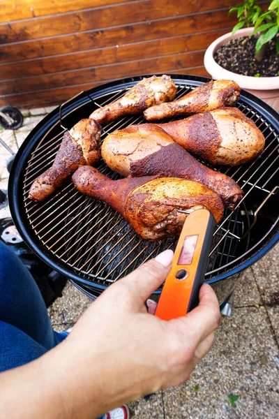 use the probe to check the cooking of the turkey legs on the grill