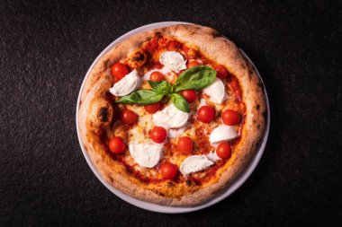 top view pizza with buffalo mozzarella and cherry tomatoes on a dark background