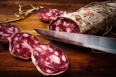 Piacenza salami cut on the wooden cutting board