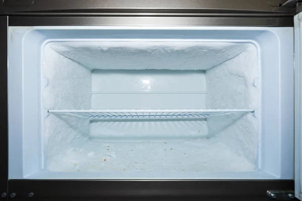 cold compartment with walls covered with ice in the refrigerator at home