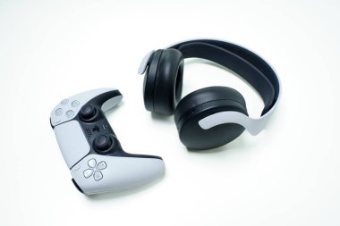 Playstation controller and headphones on white background. Udine, Italy_February 28 2023