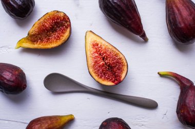 Taze incirler beyaz ahşap masada çay kaşığıyla açıldı.