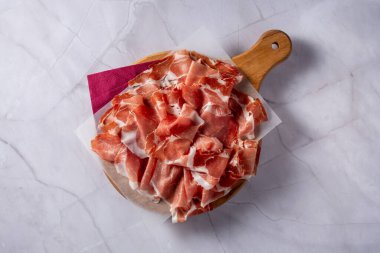 Üst Manzara San Daniele ham jambon dilimleri ahşap kesim tahtasında. beyaz mermer arkaplan