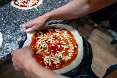 Fırına konmadan önce pizzayı kabuğun üzerine koymak.