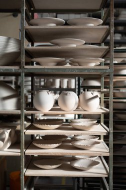 Seramik atölyesinde el yapımı seramik. Taş kaplar, vazolar ve kaseler raflarda.