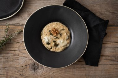 Tahta masada kabaklı risotto tabağı.