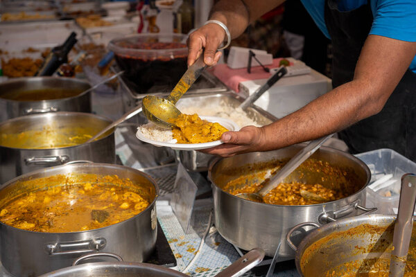 preparing a dish in the Indian cuisine stall. Street food