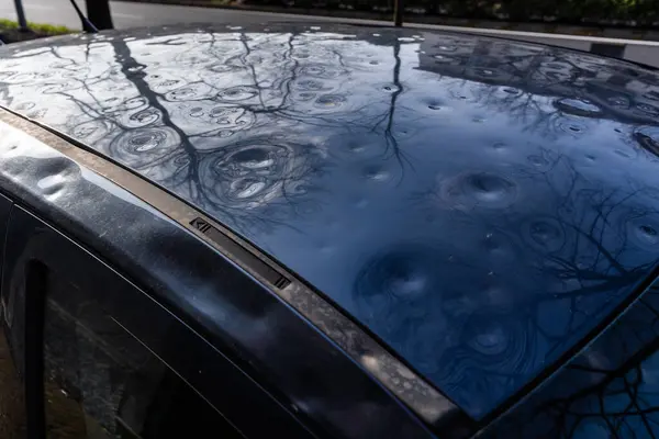 detail of the roof of the car damaged by hail. damage from natural disaster. hail damage