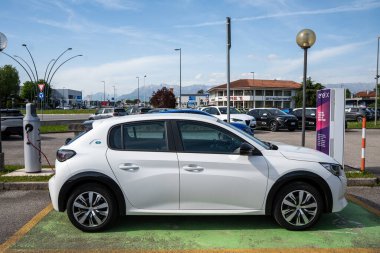 Udine, İtalya _ 28 Nisan _ 2024. Peugeot 208 elektrikli araba, şarj istasyonunda.