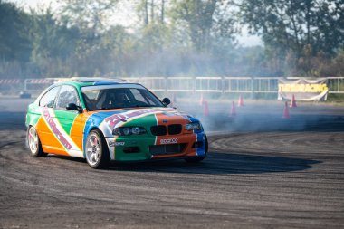 Yarış arabası hızlı bir şekilde kayıyor. Sigara lastikleri. Olağanüstü bir spor. İz. Hız. Udine, İtalya _ 21 Eylül 2024.