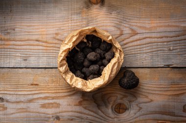 Tahta masada siyah trüf mantarlı çanta.