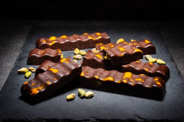 Koyu arkaplanda tuzlu fıstıklı ve fıstıklı çikolata.