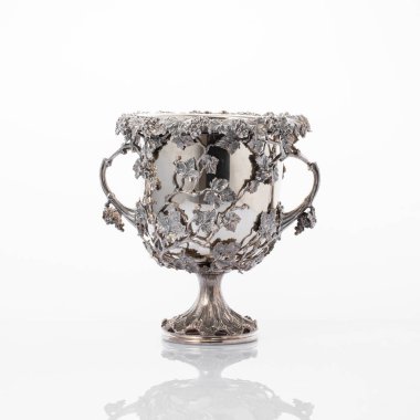 Beyaz arkaplanda yansıması olan eski gümüş vazo.