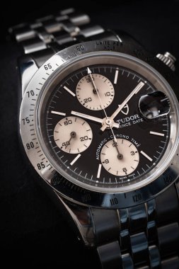 Bir Tudor kronografının siyah kadranına yakın plan, Prince Date modeli, paslanmaz çelik kılıflı 79280P referansı. Karanlık bir arkaplanda yaşam tarzı çekimi. Milan mı? İtalya _ 14 Nisan _ 2025