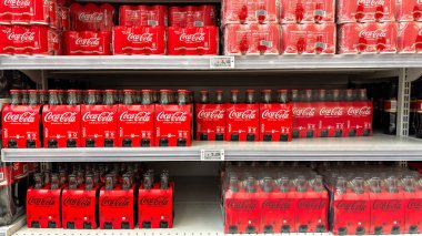 Bir mağaza rafında çeşitli Coca-Cola şişeleri ve kutu paketleri sergileniyor. Udine, İtalya. 8 Haziran 2025.