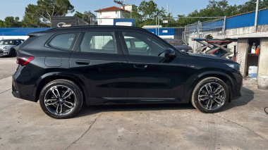 BMW iX1 xDrive30 M Sport caddeye park etmiş. Modern elektrikli SUV spor tasarımı, premium compact crossover